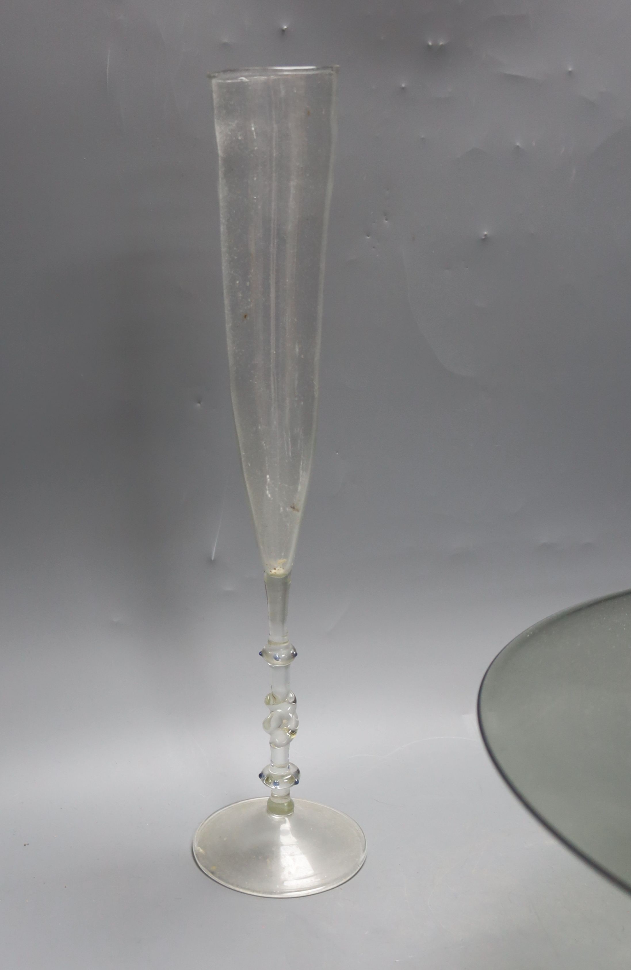 A Dutch Venetian style tall glass flute, the twisted stem with blue bead decoration, H 38cm, a 'Facon-de-Venise' style blue-tinted pedestal bowl, foliate-engraved and another glass dish (3)